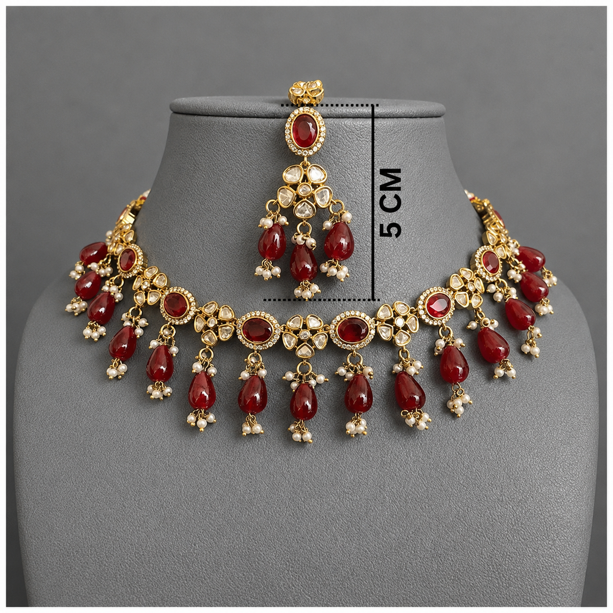 Gold-plated jewelry set with red teardrop beads, floral motifs, and white stones, displayed on a gray mannequin bust with a 5 cm height measurement overlay.